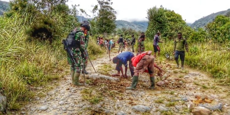 Kemanunggalan TNI, 20 Personel Satgas Pamtas Yonif Raider Bantu Perbaikan Jalan di Distrik Walesi, Papua.