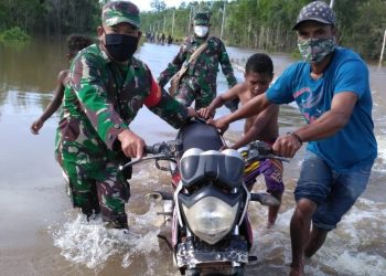 TNI-Polri Bantu Pengendara Terjebak Banjir di Jalan Trans Papua
