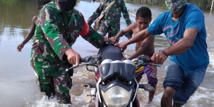 TNI-Polri Bantu Pengendara Terjebak Banjir di Jalan Trans Papua