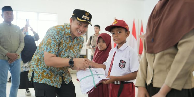 Bupati Morowali, Iksan Baharudin Abdul Rauf, saat membagikan bantuan seragam pendidikan di Kecamatan Menui