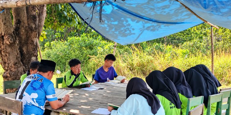 Siswa MTs Tanjung Harapan, Desa Tanjung Harapan, Kecamatan Sambori Kepulauan, Kabupaten Morowali, mengikuti kegiatan belajar di bawah tenda sederhana.
